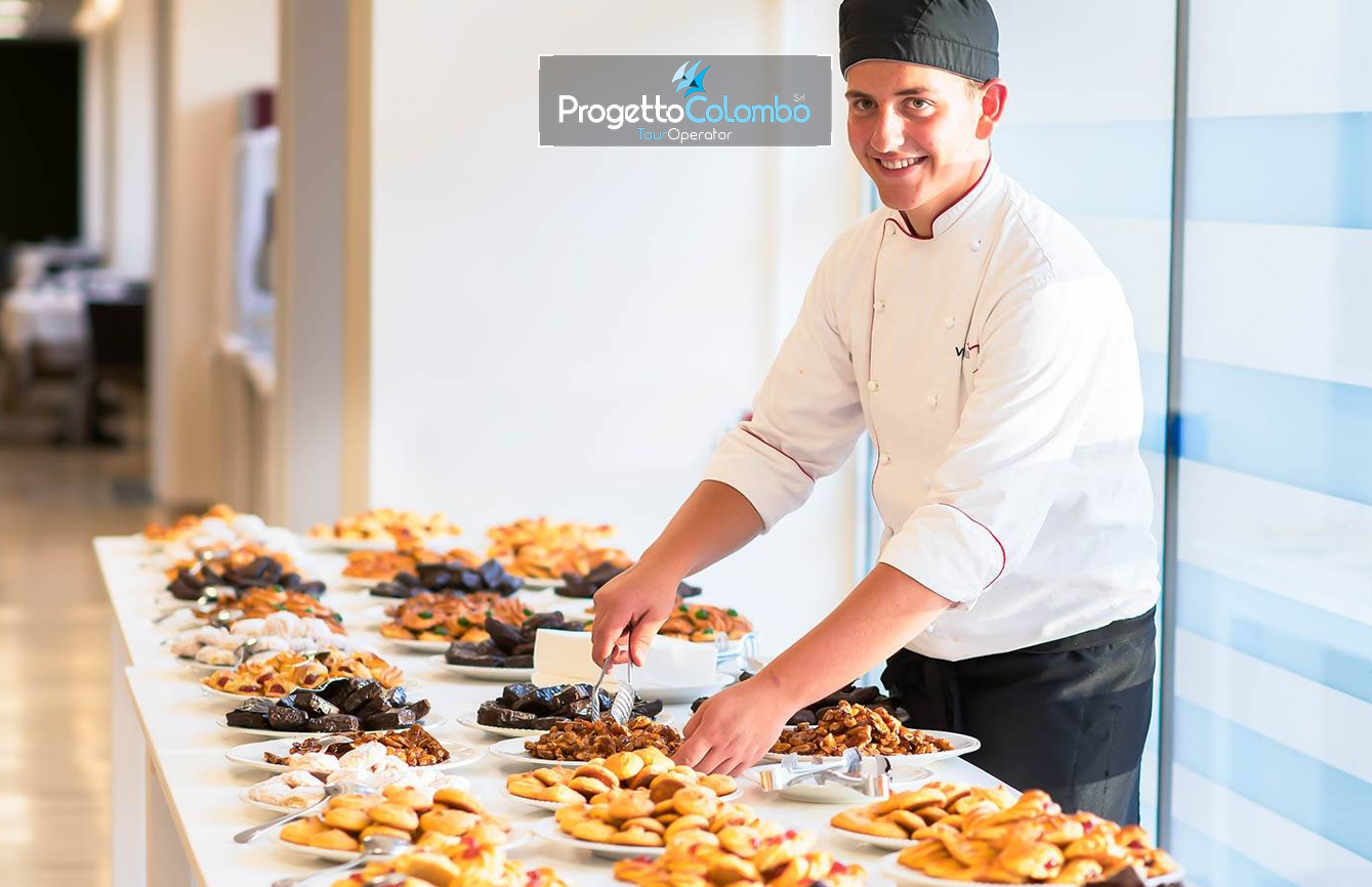 Progetto Colombo Bari, Tour Operator, Mare Italia, Voi Alimini resort, Alpitour, Bravo Club, All Inclusive, Top Club, Puglia, Salento_Dolci Spiaggia e Mare: "Spiaggia di sabbia bianca e mare cristallino del VOI Alimini Resort a Otranto, ideale per vacanze a metà settembre." Piscina: "Ampia piscina all'aperto circondata dal verde del giardino nel resort VOI Alimini in Puglia." Ristorazione: "Buffet vario e colorato nella sala ristorante del VOI Alimini Resort per gli ospiti in formula all-inclusive." Organizzazione Progetto Colombo Viaggi Bari