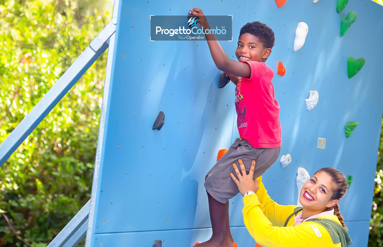 Progetto Colombo Bari, Tour Operator, Mare Italia, Voi Alimini resort, Alpitour, Bravo Club, All Inclusive, Top Club, Puglia, Salento_Giochi Spiaggia e Mare: "Spiaggia di sabbia bianca e mare cristallino del VOI Alimini Resort a Otranto, ideale per vacanze a metà settembre." Piscina: "Ampia piscina all'aperto circondata dal verde del giardino nel resort VOI Alimini in Puglia." Ristorazione: "Buffet vario e colorato nella sala ristorante del VOI Alimini Resort per gli ospiti in formula all-inclusive." Organizzazione Progetto Colombo Viaggi Bari