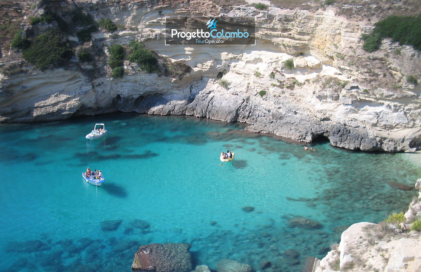 Progetto Colombo Bari, Tour Operator, Mare Italia, Voi Alimini resort, Alpitour, Bravo Club, All Inclusive, Top Club, Puglia, Salento_Mare Spiaggia e Mare: "Spiaggia di sabbia bianca e mare cristallino del VOI Alimini Resort a Otranto, ideale per vacanze a metà settembre." Piscina: "Ampia piscina all'aperto circondata dal verde del giardino nel resort VOI Alimini in Puglia." Ristorazione: "Buffet vario e colorato nella sala ristorante del VOI Alimini Resort per gli ospiti in formula all-inclusive." Organizzazione Progetto Colombo Viaggi Bari