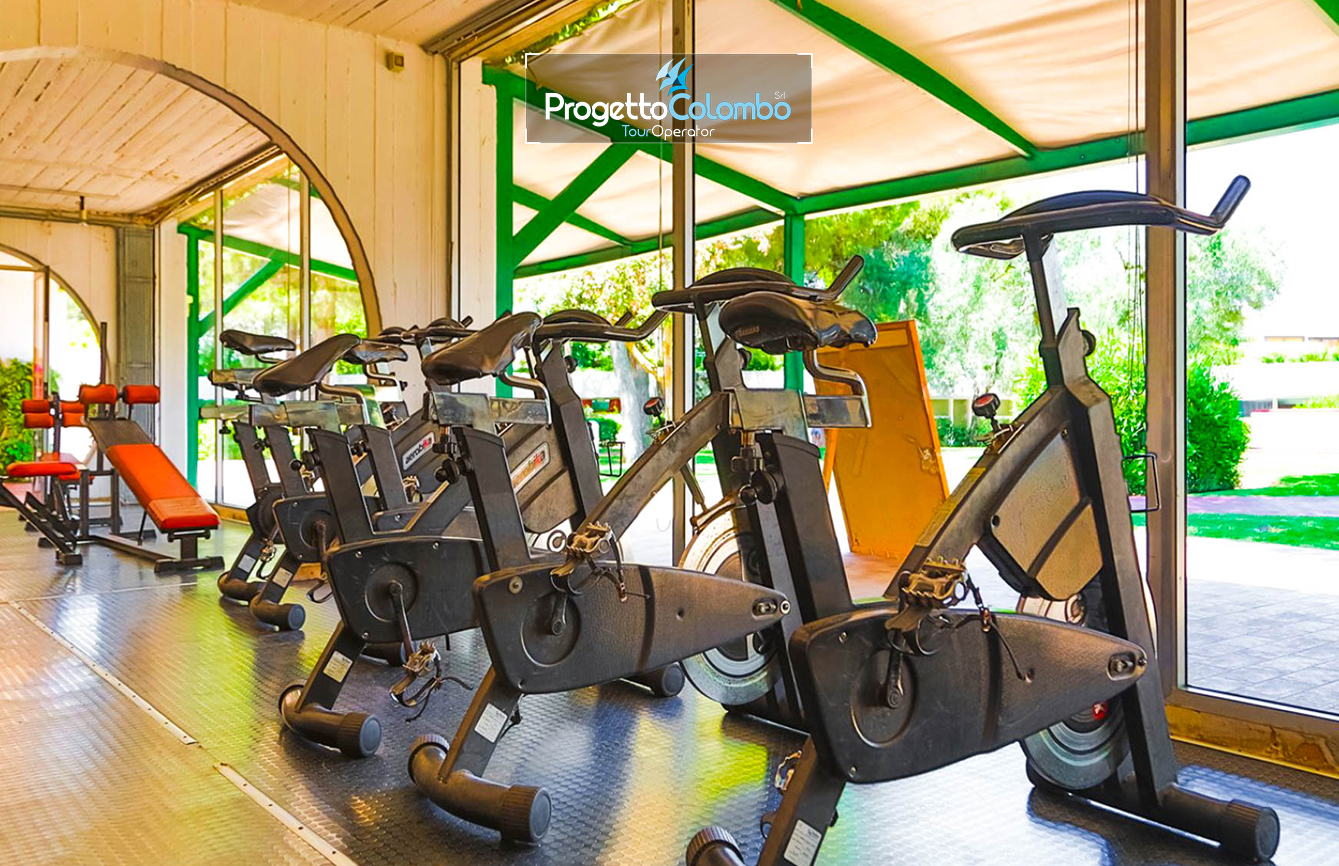 Progetto Colombo Bari, Tour Operator, Mare Italia, Voi Alimini resort, Alpitour, Bravo Club, All Inclusive, Top Club, Puglia, Salento_Palestra Spiaggia e Mare: "Spiaggia di sabbia bianca e mare cristallino del VOI Alimini Resort a Otranto, ideale per vacanze a metà settembre." Piscina: "Ampia piscina all'aperto circondata dal verde del giardino nel resort VOI Alimini in Puglia." Ristorazione: "Buffet vario e colorato nella sala ristorante del VOI Alimini Resort per gli ospiti in formula all-inclusive." Organizzazione Progetto Colombo Viaggi Bari