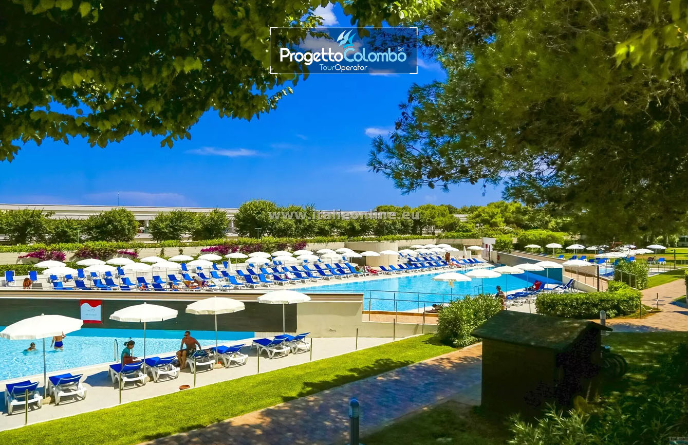 Progetto Colombo Bari, Tour Operator, Mare Italia, Voi Alimini resort, Alpitour, Bravo Club, All Inclusive, Top Club, Puglia, Salento_Piscina Spiaggia e Mare: "Spiaggia di sabbia bianca e mare cristallino del VOI Alimini Resort a Otranto, ideale per vacanze a metà settembre." Piscina: "Ampia piscina all'aperto circondata dal verde del giardino nel resort VOI Alimini in Puglia." Ristorazione: "Buffet vario e colorato nella sala ristorante del VOI Alimini Resort per gli ospiti in formula all-inclusive." Organizzazione Progetto Colombo Viaggi Bari