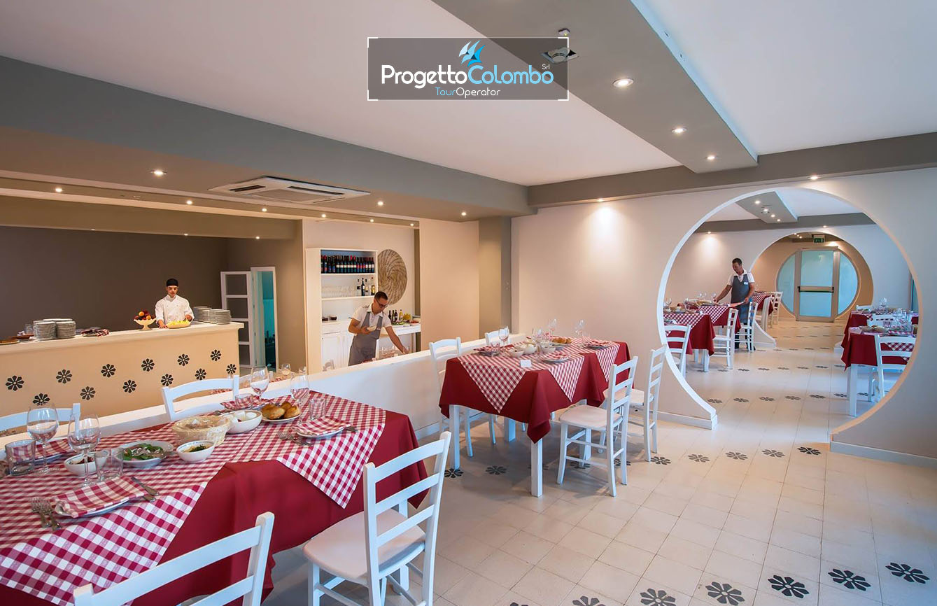 Progetto Colombo Bari, Tour Operator, Mare Italia, Voi Alimini resort, Alpitour, Bravo Club, All Inclusive, Top Club, Puglia, Salento_Ristorante Spiaggia e Mare: "Spiaggia di sabbia bianca e mare cristallino del VOI Alimini Resort a Otranto, ideale per vacanze a metà settembre." Piscina: "Ampia piscina all'aperto circondata dal verde del giardino nel resort VOI Alimini in Puglia." Ristorazione: "Buffet vario e colorato nella sala ristorante del VOI Alimini Resort per gli ospiti in formula all-inclusive." Organizzazione Progetto Colombo Viaggi Bari